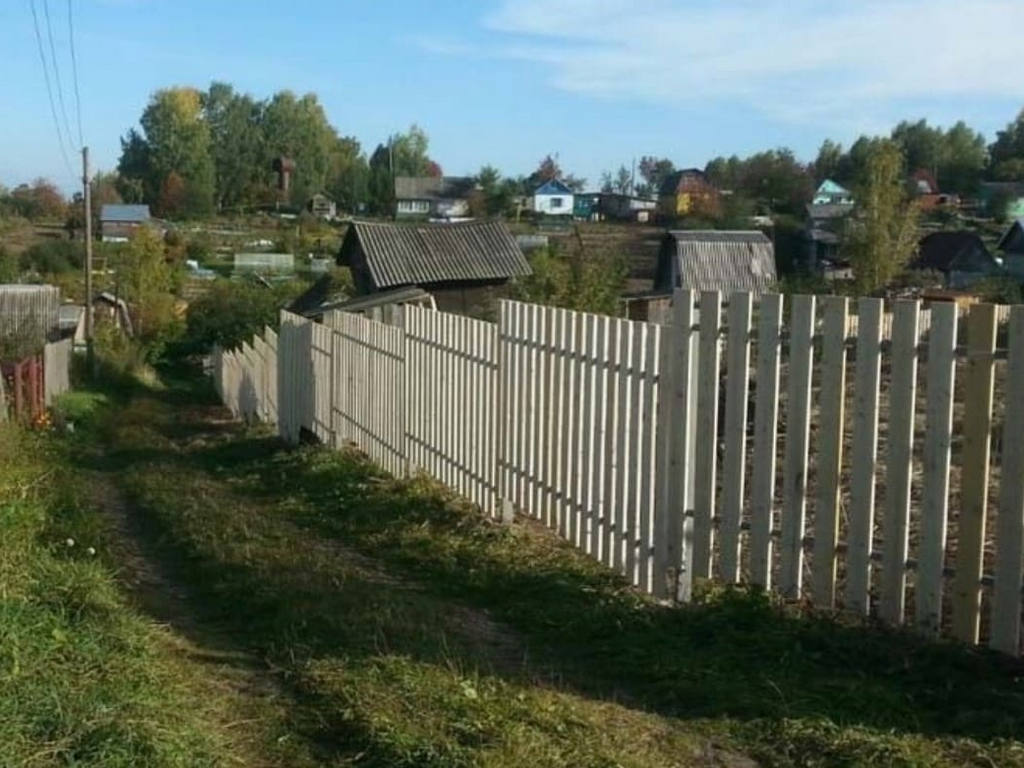 деревянный забор на участке с большим уклоном местности